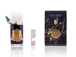 An Ivory white rosebud in a black glass vase with a gold crest, rose petal perfurme and a black crested gold gift box, presented for gifting at Natashas Skin Spa Southbank, City Road Melbourne beauty salon and florist