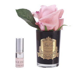 
                  
                    White peach rosebud in a black glass vase with a bottle of intensively scented rose petal perfume spray
                  
                